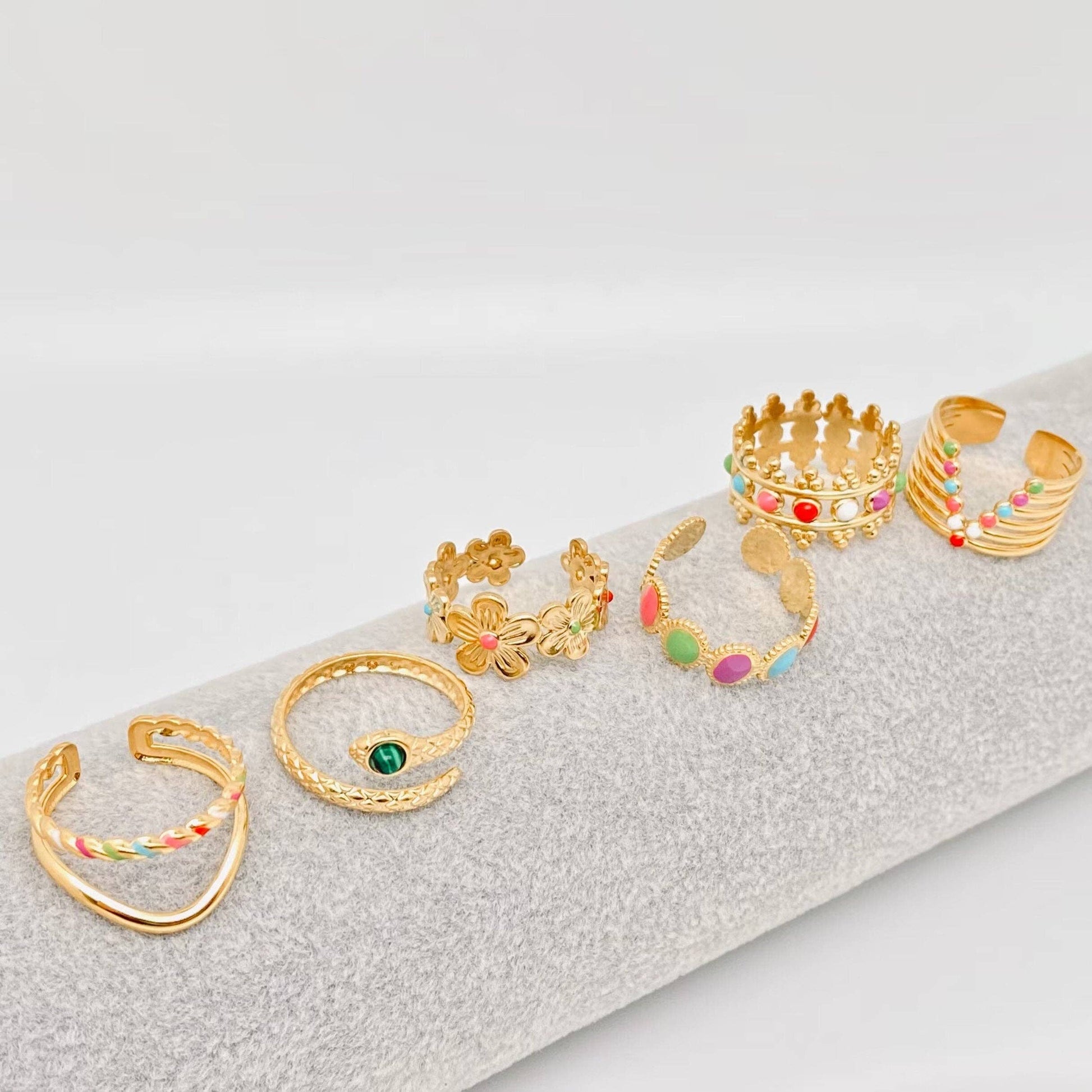 Gold plated stainless steel adjustable crown ring with colored enamel on white background