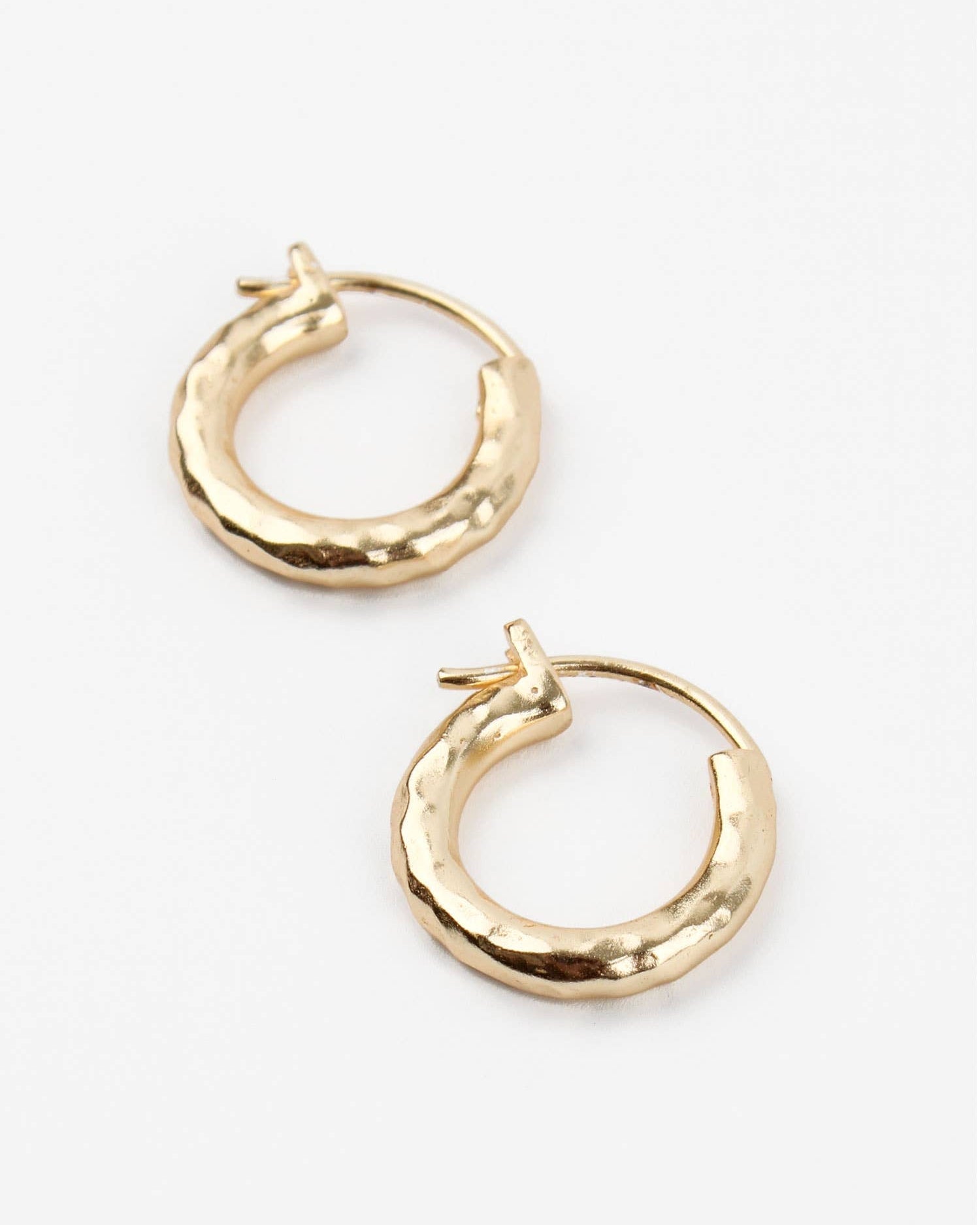 Beaten Gold hoop earrings on a white background