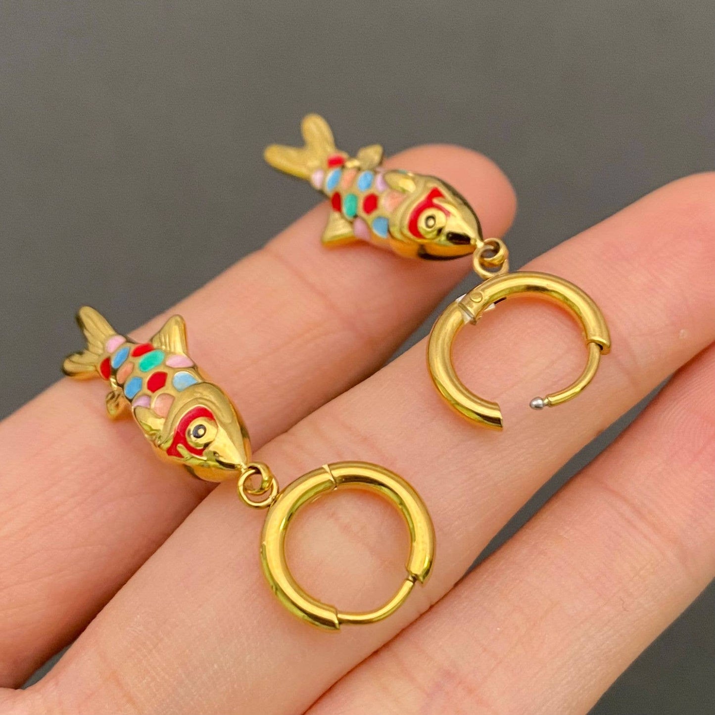 Gold plated fish earrings showing size and fit