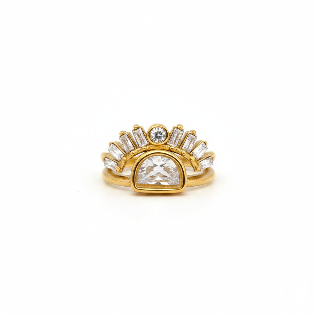Gold ring with a large central diamond and smaller diamonds on a finger against a gray background