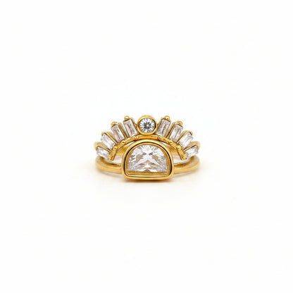 Gold ring with a large central diamond and smaller diamonds on a finger against a gray background