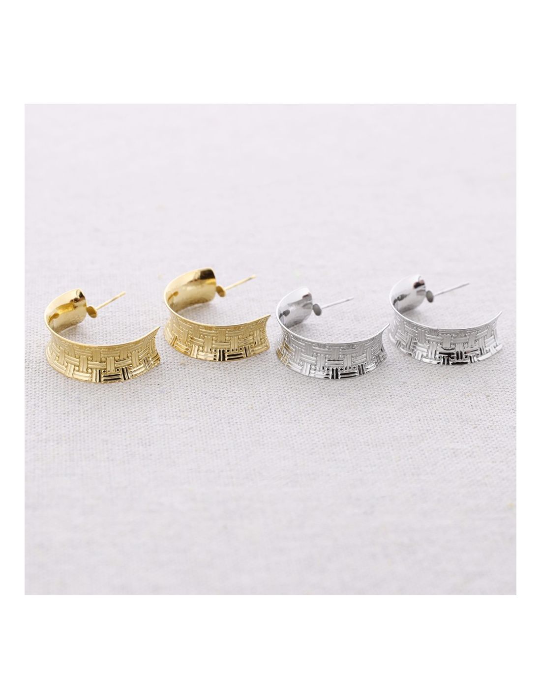 Two pairs of hoop earrings, one gold and one silver, on a white background.